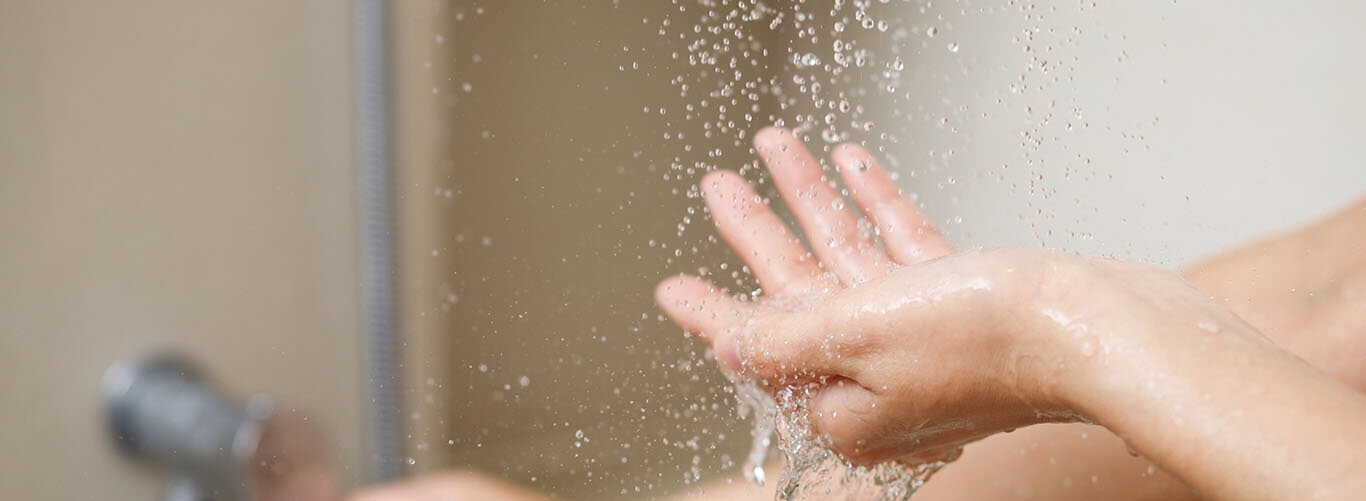 Eine Frau misst mit der Hand die Wassertemperatur